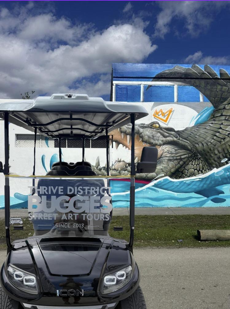 Open air buggy parked near Thrive District murals