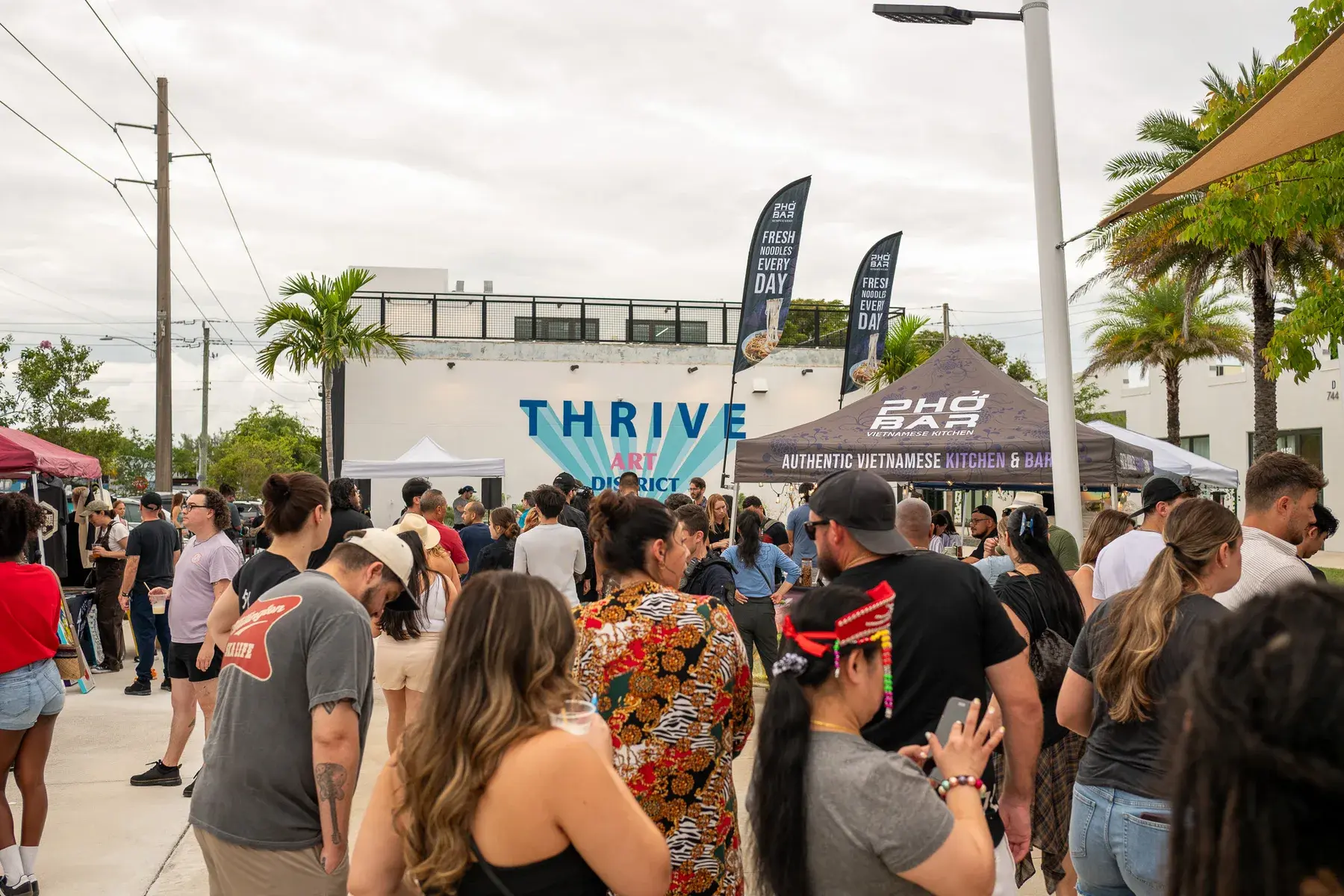 Outdoor vendor booths and visitors at Thrive District