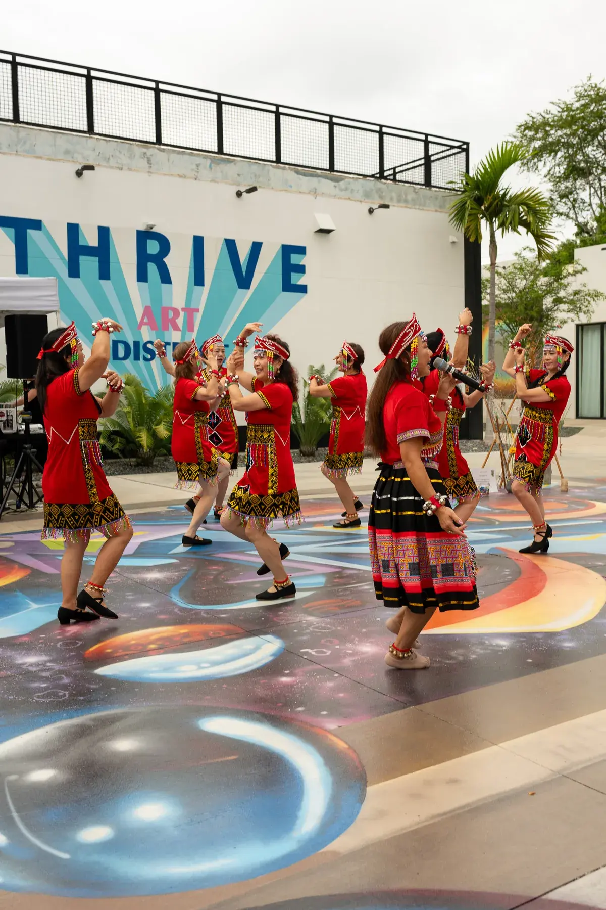 Crowd watching a performance in front of the Thrive District wall